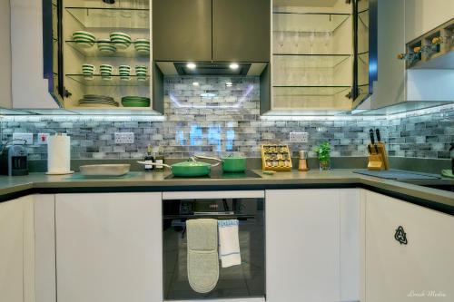a kitchen with white cabinets and an oven at Luxury Studio in Wembley in Wembley
