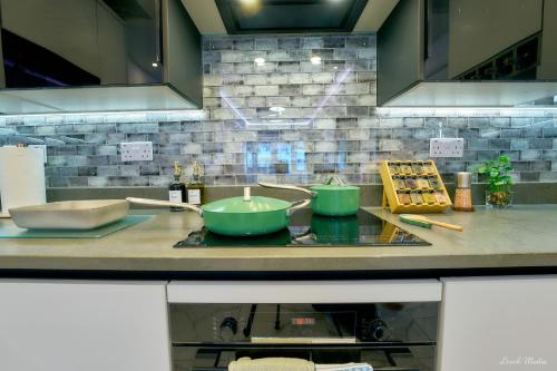 a kitchen counter with two green bowls on a stove at Luxury Studio in Wembley in Wembley