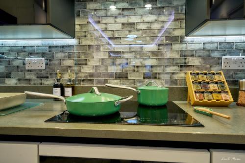 a kitchen counter with two green pots on a stove at Luxury Studio in Wembley in Wembley