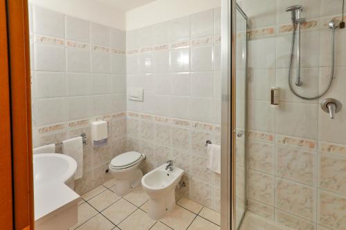une salle de bain avec toilettes, lavabo et douche dans l'établissement Hotel Molino Rosso, à Imola