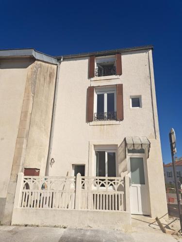 a building with a white fence in front of it at Chez Bigoude maison 4 voyageurs in Chaumont