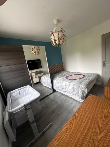 a small bedroom with a bed and a mirror at Maison avec piscine chauffée, plages du débarquement in Crouay