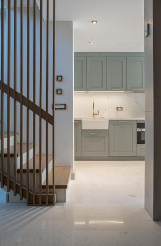 a kitchen with gray cabinets and a staircase at Mimosa Mansions in Bodrum City