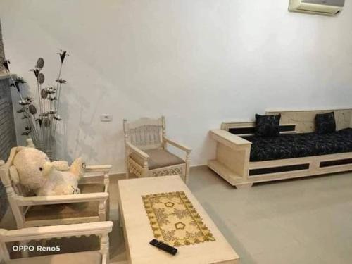 a living room with two beds and a table at Dar yess in Bin Rhilouf