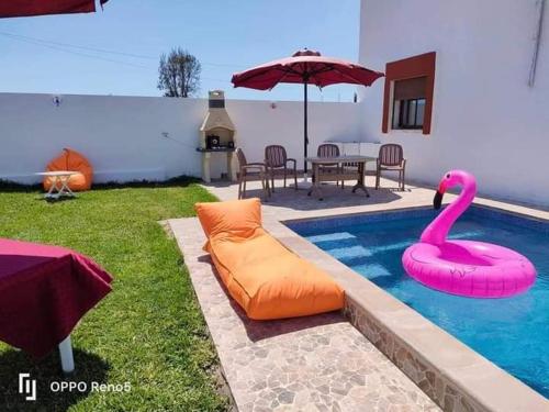 a swimming pool with a pink swan in it at Dar yess in Bin Rhilouf