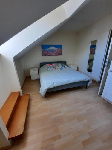 a bedroom with a bed and a wooden floor at Wool INN Le Colombier in Milly-la-Forêt