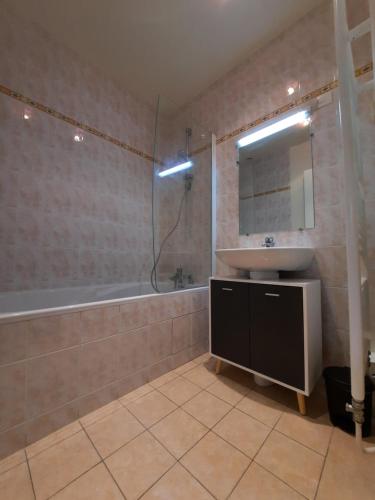 a bathroom with a sink and a tub and a mirror at Wool INN Le Colombier in Milly-la-Forêt
