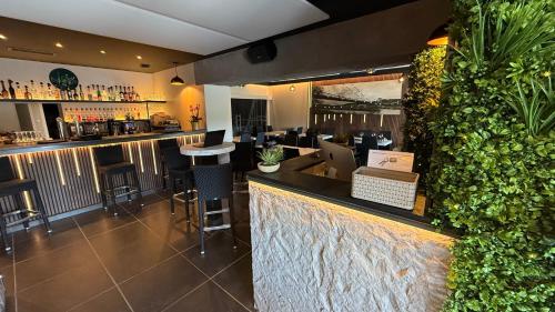 a bar in a restaurant with a green wall at Logis Hôtel Restaurant Bellevue in Saint-Martin-dʼArdèche