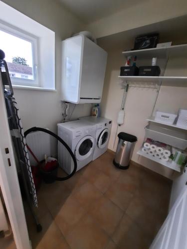 a kitchen with a washing machine and a microwave at Wool INN Le Colombier in Milly-la-Forêt