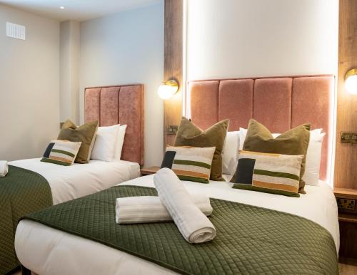 two beds in a hotel room with white and green at The Woodquay Townhouse in Galway