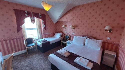 a hotel room with two beds and a window at White Heather Hotel in Llandudno