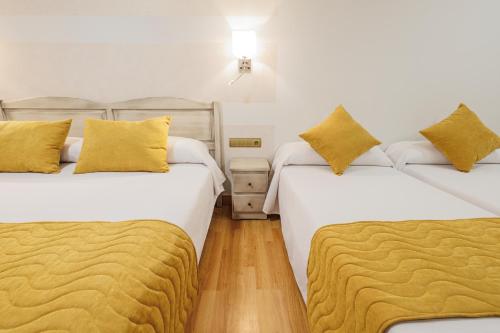 two beds sitting next to each other in a room at Hotel Pattaya in Mocejón