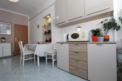 a kitchen with a table and a microwave on a counter at Guest House Barocco in Rovinj