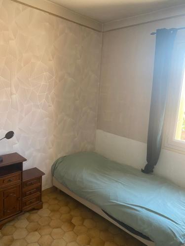une petite chambre avec un lit et une fenêtre dans l'établissement Grande maison de ville T7, à Perpignan