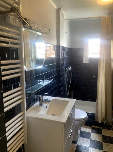 une salle de bain avec un lavabo et des toilettes dans l'établissement Grande maison de ville T7, à Perpignan