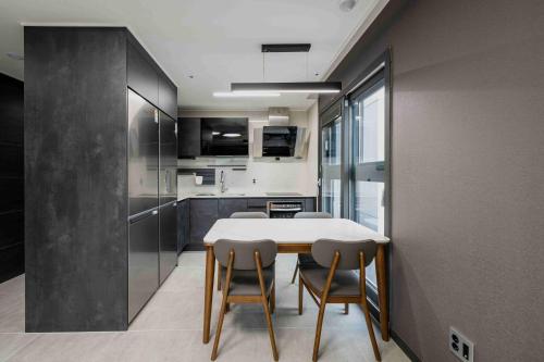 a kitchen with a table and chairs in a room at Odays Osiria Residence in Busan