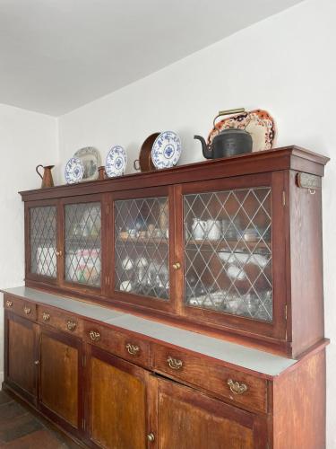 a wooden cabinet with dishes on top of it at Kilmartin House - Georgian House on Private Estate and Farm in Greystones