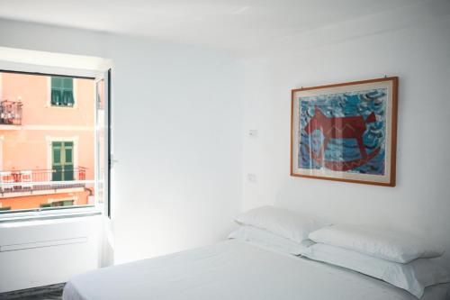 una camera da letto con un letto bianco e una finestra di Costellino 5 Terre a Riomaggiore