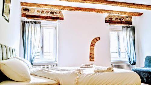 a bedroom with a bed and two windows at IL CUORE glamour DEL FESTiVAL -100mq con JACUZZi- in Trento