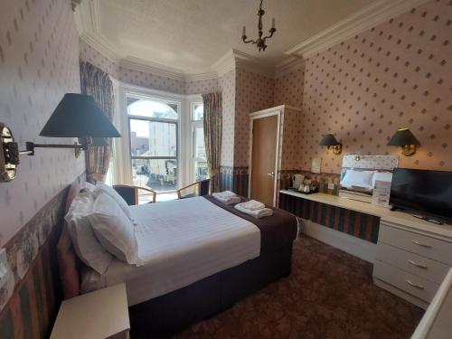 a hotel room with a bed and a television at White Heather Hotel in Llandudno
