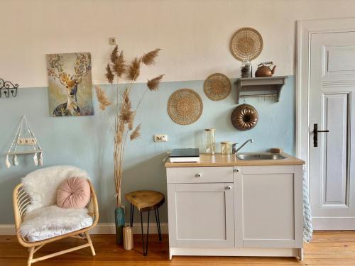a kitchen with a counter and a chair and a sink at Bauernhofvilla nur für Frauen Woman only in Niemegk
