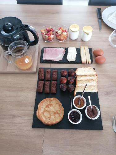 - une table avec un plateau de nourriture avec du pain et d'autres aliments dans l'établissement Bienvenue chez nous, à Mouchamps