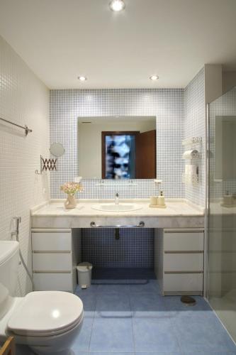 a bathroom with a sink and a toilet and a mirror at Sweet Caroline Palm-Mar in Palm-Mar