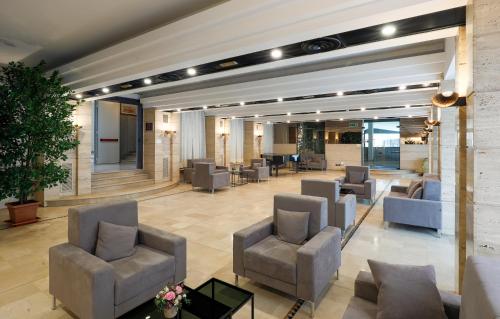 a lobby with couches and chairs in a building at Hotel Molino Rosso in Imola