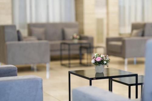 a black table with a vase of flowers on it at Hotel Molino Rosso in Imola