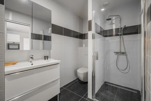 une salle de bain blanche avec une douche et un lavabo dans l'établissement R'Apparts T2 Bleu D'Alsace, à Grenoble