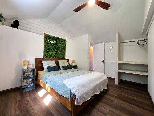 a bedroom with a bed and a green painting on the wall at L'Echappée Tropicale -- L'échappée VERTE -- Oasis Bleu Lagon & Vert Forêt, T4 avec grande terrasse, à 5min de la plage in Étang-Salé les Bains