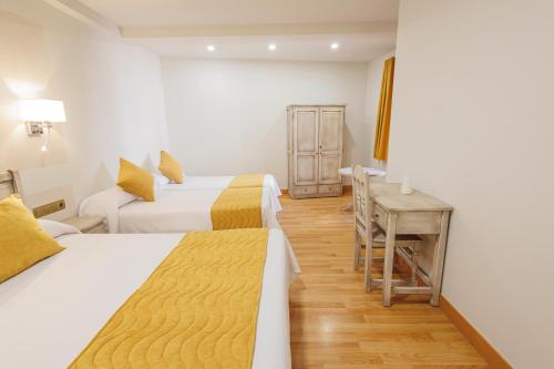 a hotel room with two beds and a table at Hotel Pattaya in Mocejón