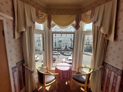 a room with a table and two chairs and a window at White Heather Hotel in Llandudno