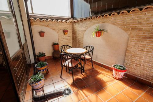 a patio with a table and chairs and plants at Hotel Pattaya in Mocejón