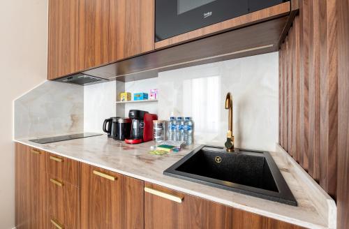 un comptoir de cuisine avec un évier et un micro-ondes dans l'établissement Mid term l Luxury and Cozy, à Paris