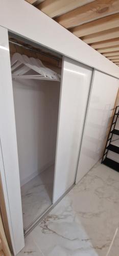 two closets with white doors in a room at Apartament P&P in Toruń