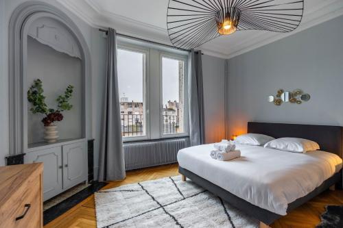 une chambre avec un lit et une grande fenêtre dans l'établissement Le Chic de Foch - 5min à Pied de la Gare, à Nancy