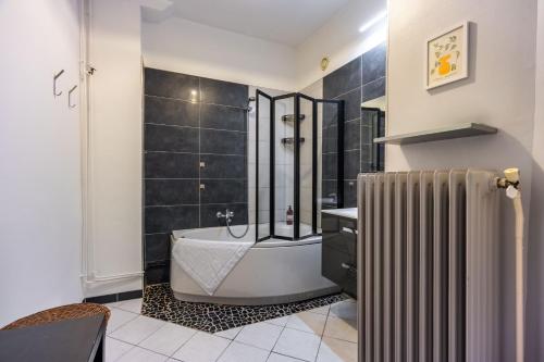La salle de bains est pourvue d'une baignoire et d'un radiateur. dans l'établissement Le Chic de Foch - 5min à Pied de la Gare, à Nancy