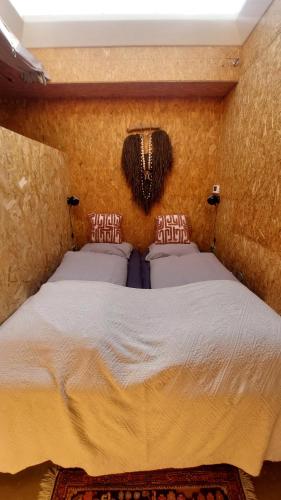 Oud-AdeにあるHut-Spot, comfortabel houten tuinhuisのベッドルーム1室(壁に大型ベッド1台付)