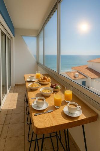 - une table avec des aliments pour le petit-déjeuner et des verres de jus d'orange dans l'établissement L'Échappée Vendéenne - T2 cosy en bord de mer, à Saint-Hilaire-de-Riez