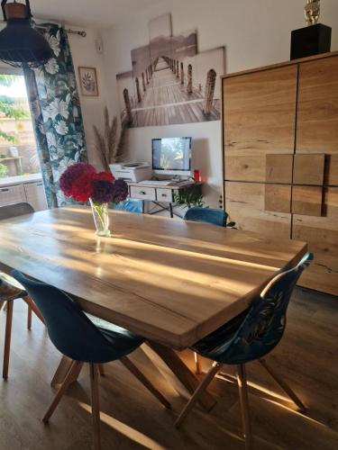 une table en bois avec un vase de fleurs dessus dans l'établissement L'oiseau du paradis, à La Celle-sous-Gouzon