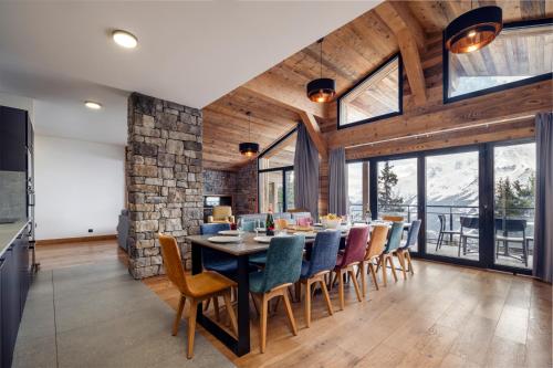 une salle à manger avec une table et des chaises dans l'établissement Madame Vacances Résidence L'Orée du Bois, à La Rosière