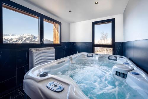 ein Whirlpool in einem Zimmer mit Bergen in der Unterkunft Madame Vacances Résidence L'Orée du Bois in La Rosière