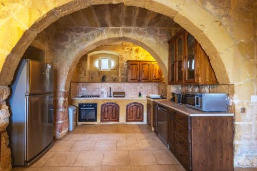 a large kitchen with an archway in a building at Villeleynah Holiday Home in Munxar