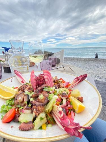 une assiette de nourriture sur une table à côté de la plage dans l'établissement Cannes hills villa with garden and parking, au Cannet