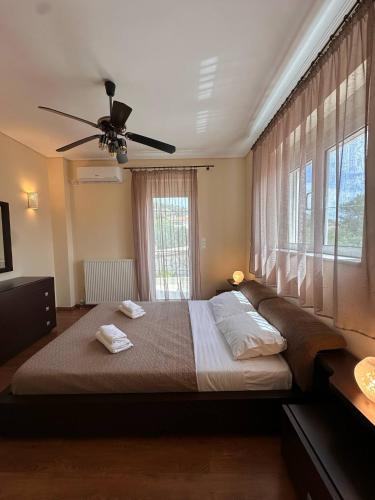 ein Schlafzimmer mit einem großen Bett und einem Deckenventilator in der Unterkunft La Maison in Áyios Nikólaos