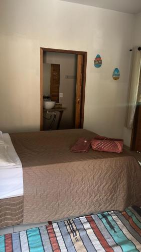 a large bed in a room with a bathroom at Casa da Arvore in Mariana