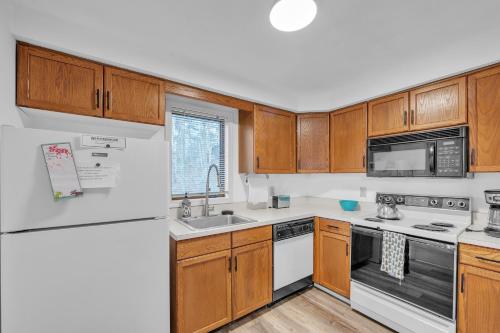 una cucina con mobili in legno e un frigorifero bianco di Little Cloud 10M - Retreat with Adirondack Charm a North Creek