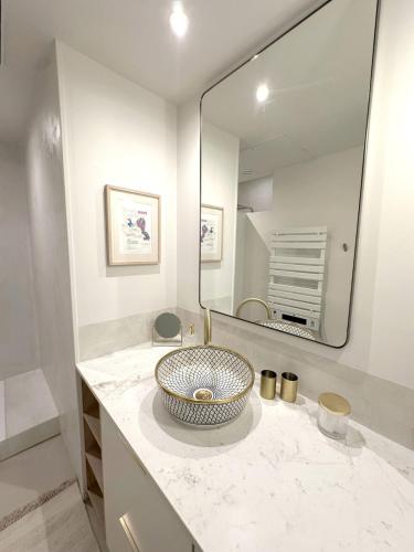 une salle de bain avec un lavabo et un grand miroir dans l'établissement Maison de Charme Centre Roquette, à Arles