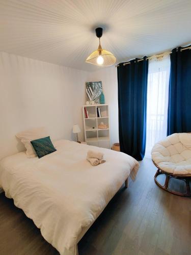 - une chambre avec un grand lit blanc et des rideaux bleus dans l'établissement Cocon urbain proche La Défense-Paris - logement entier, à Colombes